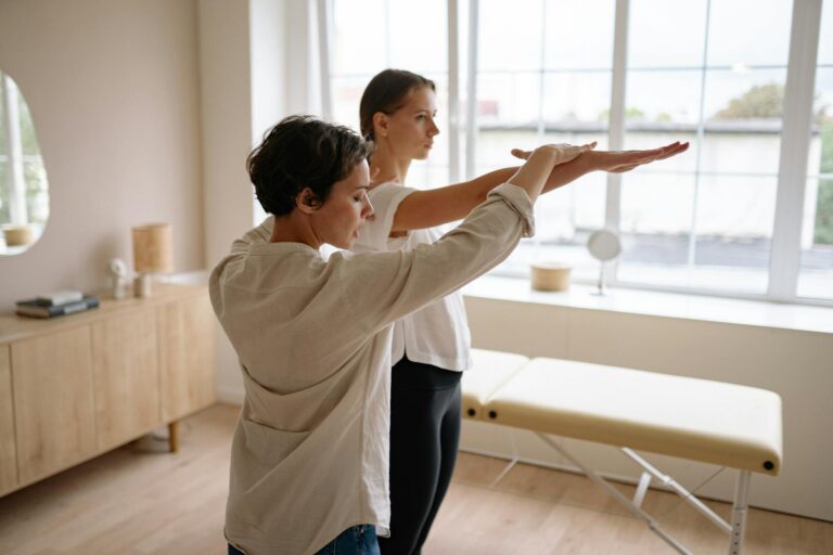 A therapist helps a client with therapeutic exercises in a wellness clinic.